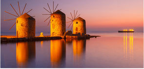 Three windmills at sunset in Greece