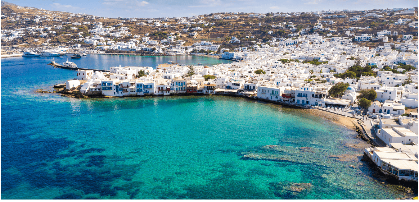 The Mykonos coastline with turquoise waters and whitewashed houses stretching across the land